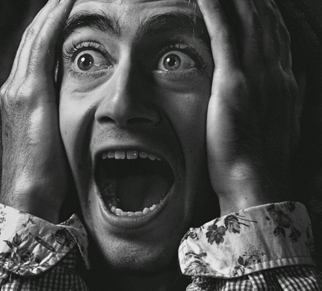Close-up of a person in expressive shock, black and white portrait.