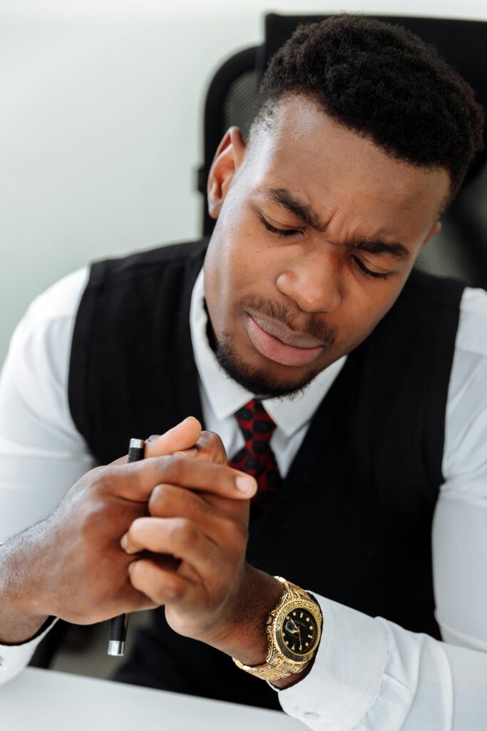 Business professional deep in thought wearing black vest and white shirt in office setting.